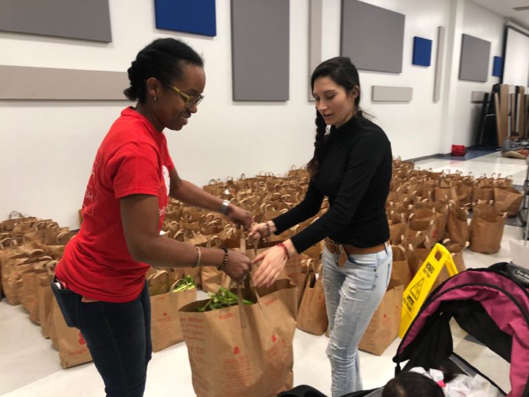 Brighter Bites volunteers handing bags of healthy food to families.